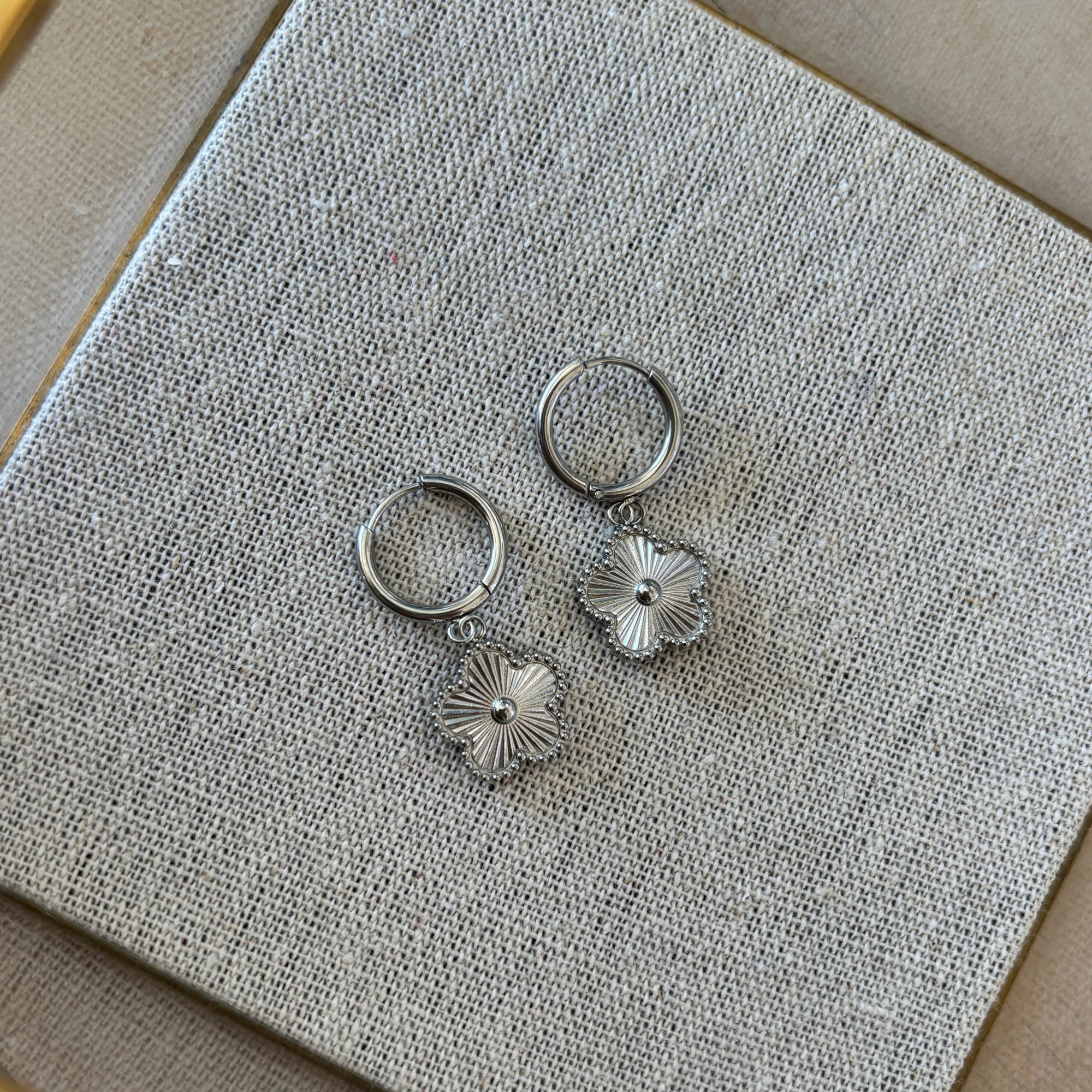 Silver rings with floral designs on a textured gray surface