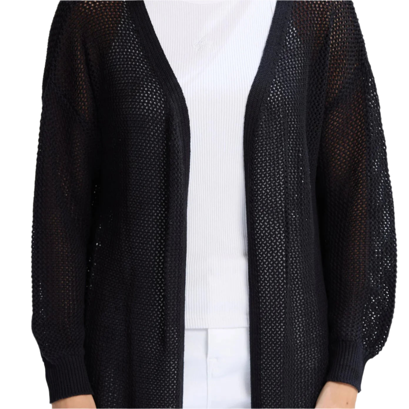 Person wearing a black open-knit cardigan over a white outfit on a light gray background