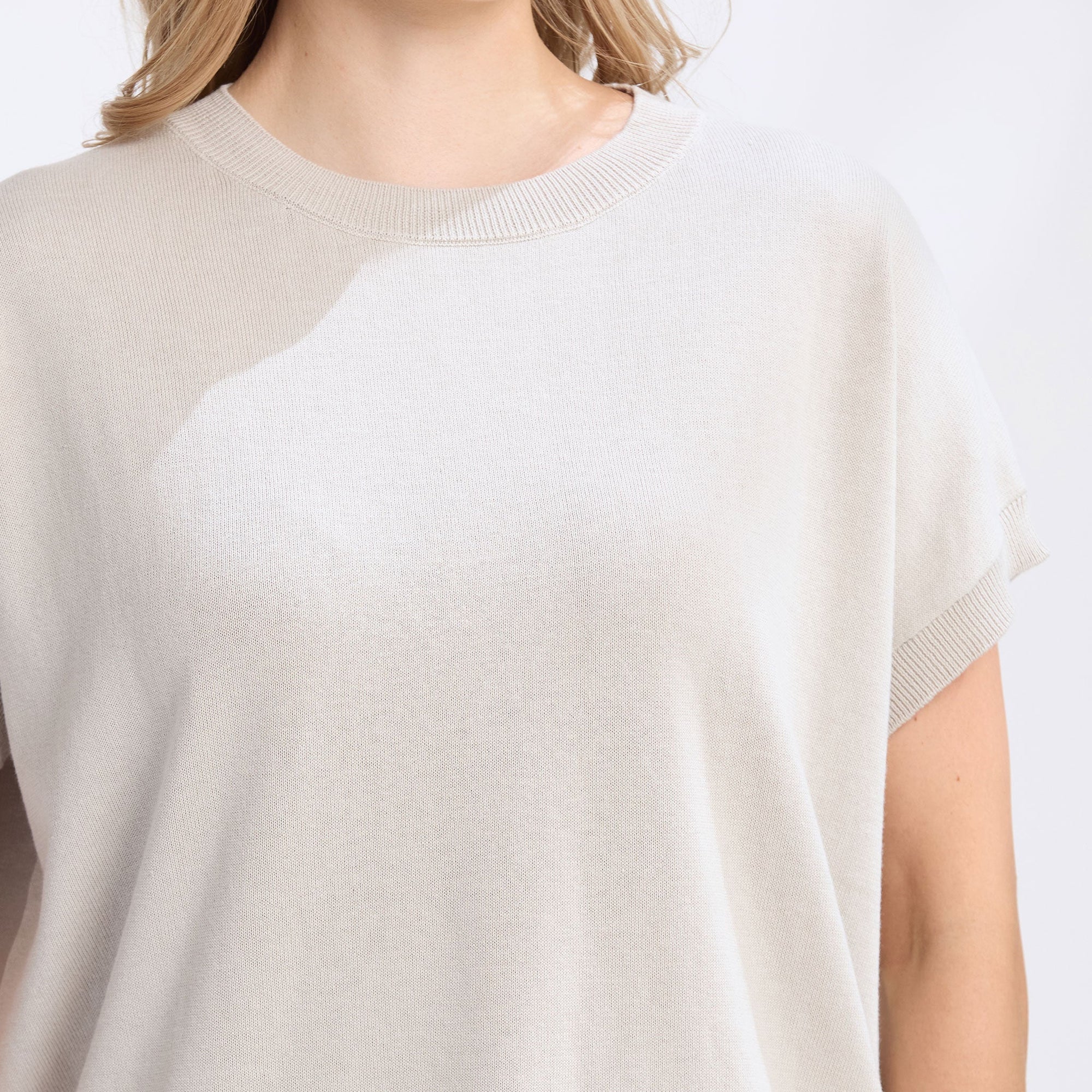 White t-shirt worn by a person on a white background