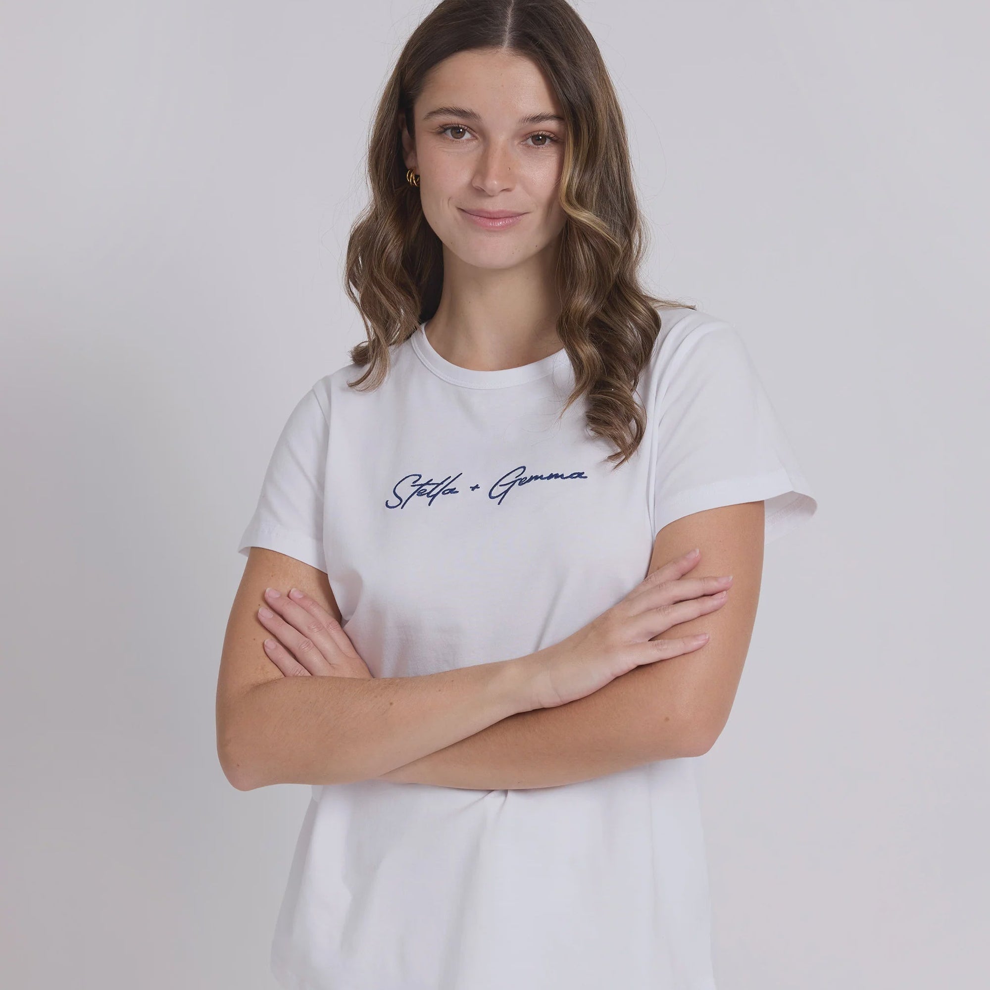 Woman wearing a white t-shirt with text on a plain background