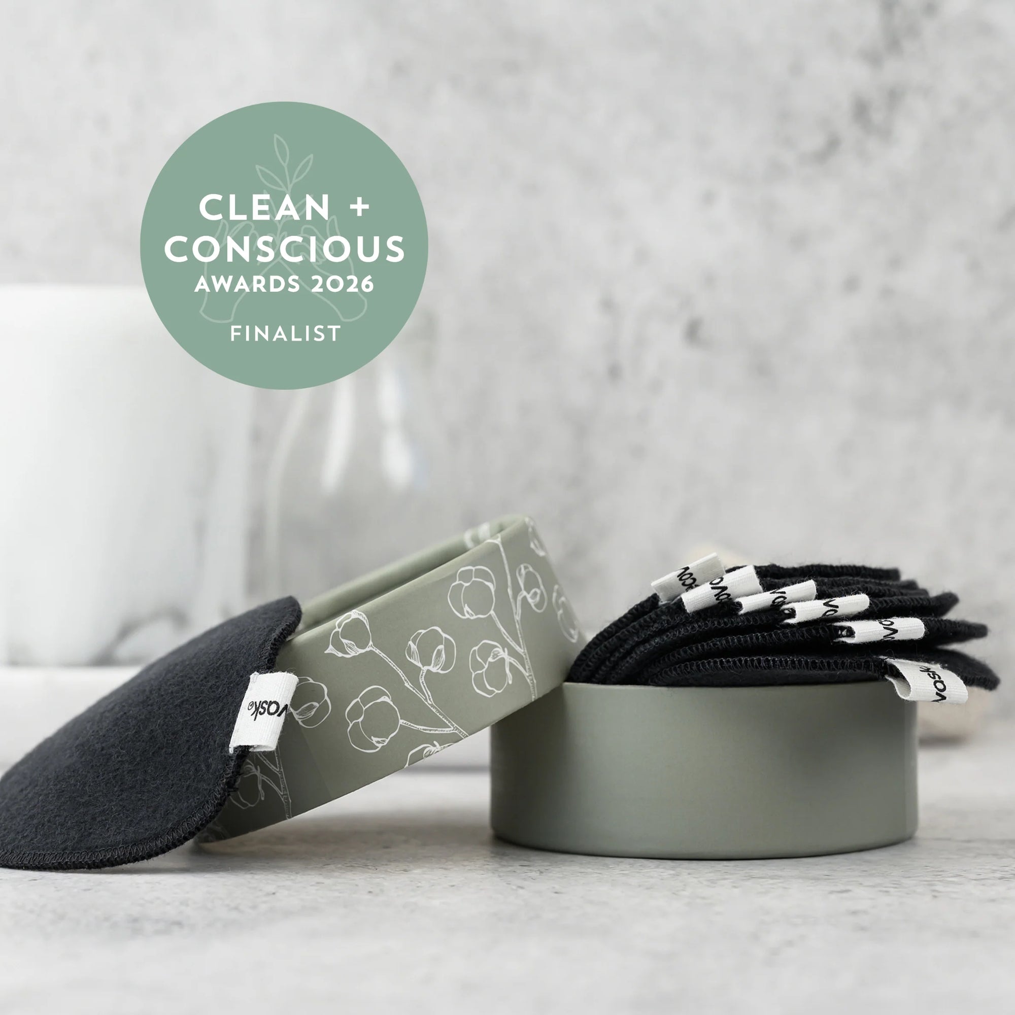 Meditation accessories including a gray headband, eye pillow, and folded blanket on a light surface with 'Clean + Conscious Awards 2026 Finalist' badge.