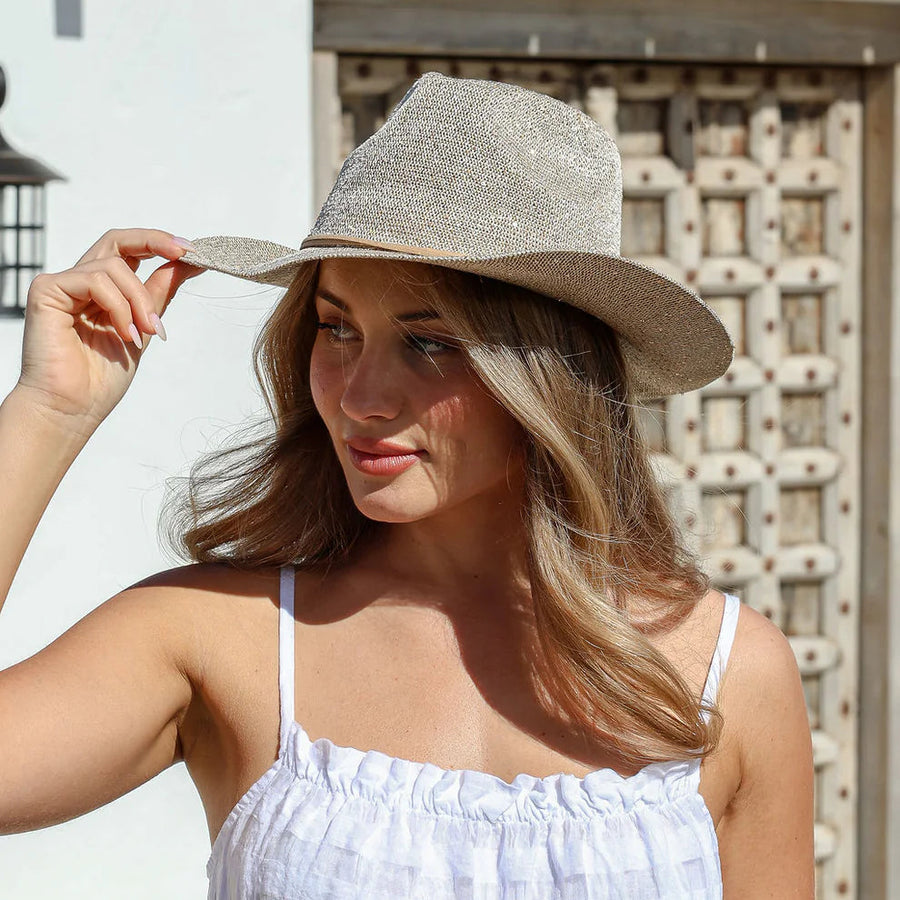 Woman wearing a gray hat and white dress outdoors