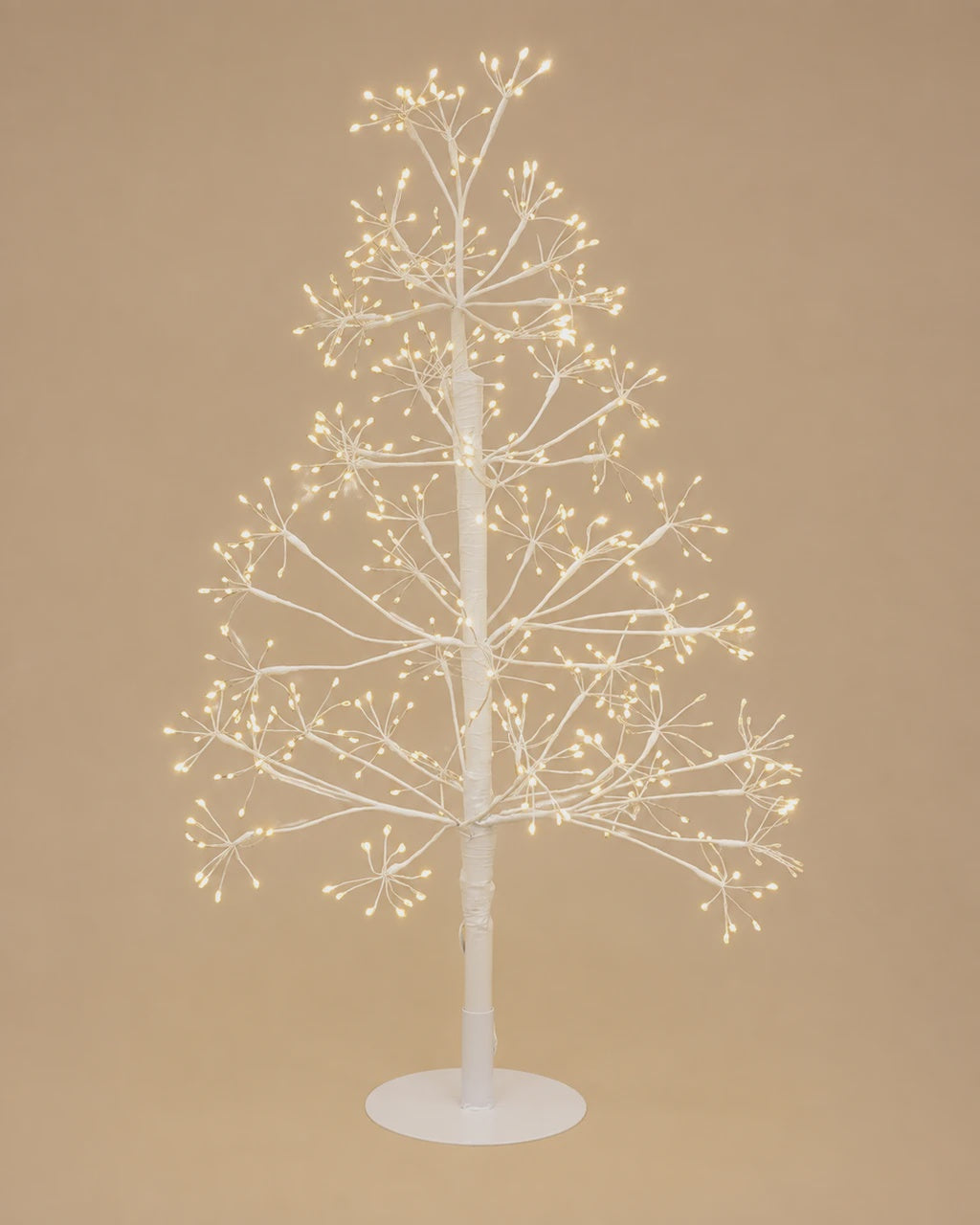 A white bare-branched Christmas tree with warm white LED lights on a matching white round base, set against a solid beige background.