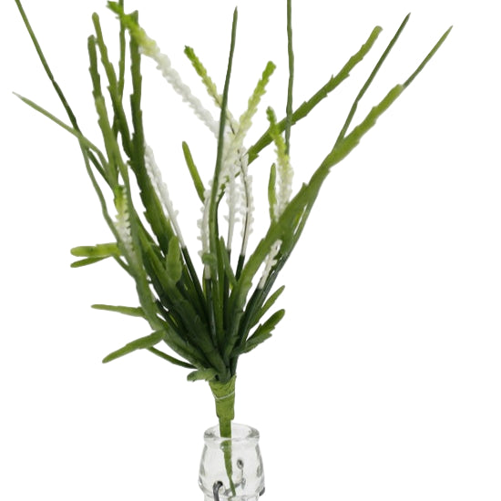 Artificial green plant in a clear glass vase on a white background