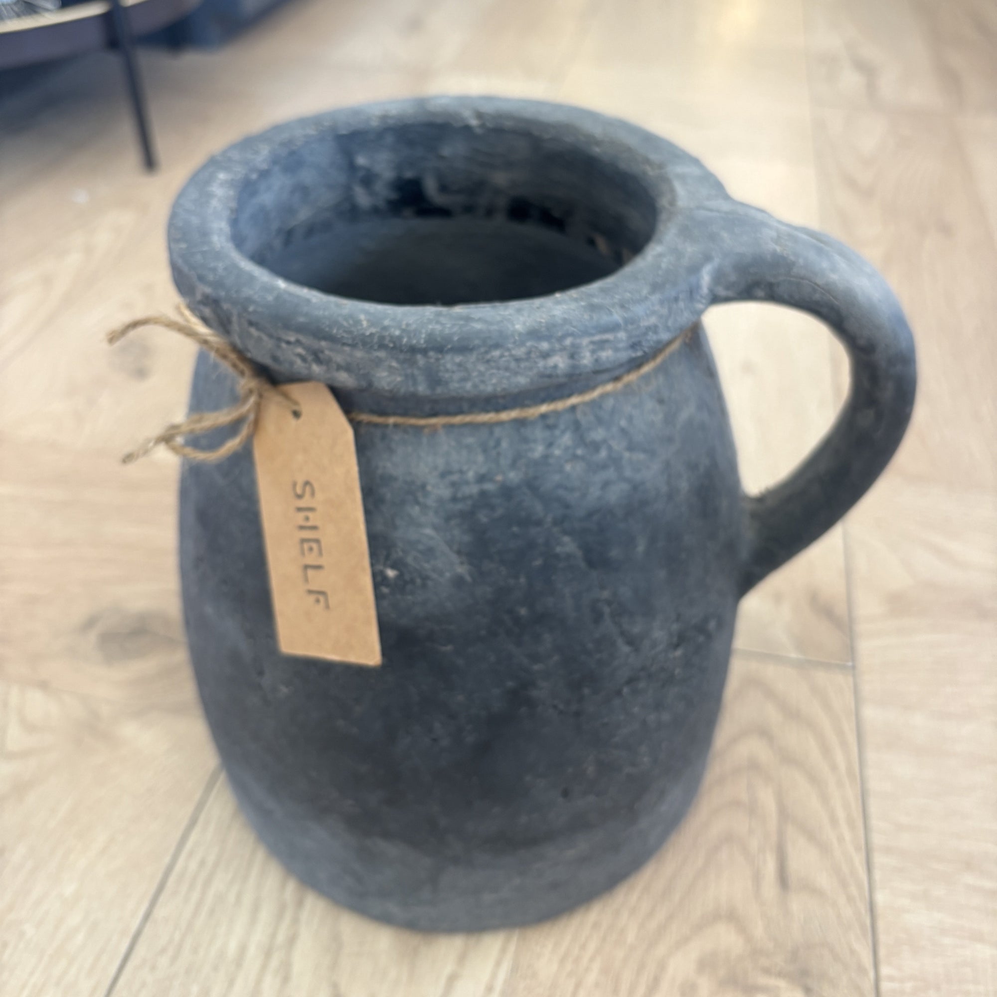 Cement mug with a tag on a wooden floor