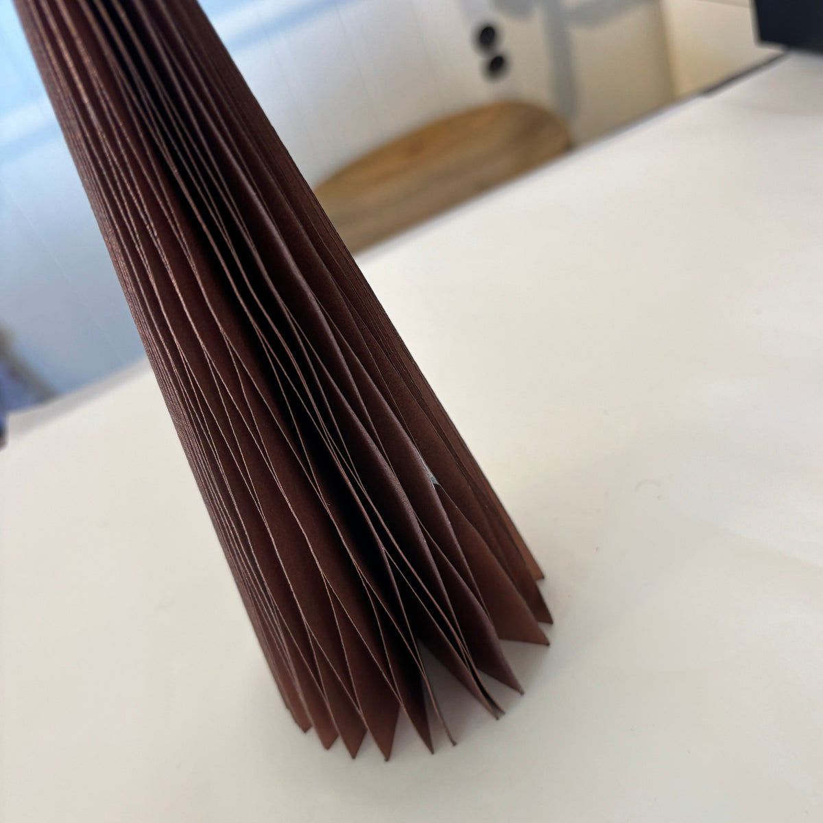 Close-up of a stack of brown paper bags on a white surface.