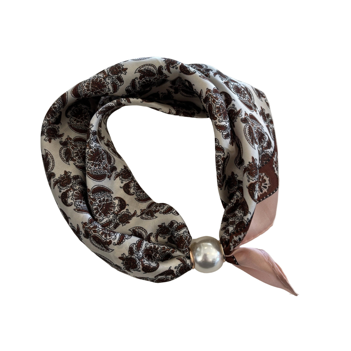 A looped scarf with a brown and black floral damask pattern on a cream background, featuring a light pink satin ribbon tie and a decorative silver pearl clasp, laid flat on a white fabric background.

