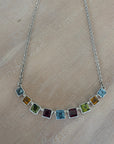 Necklace with square gemstones on a beige surface