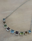 Necklace with square pendant on a wooden surface