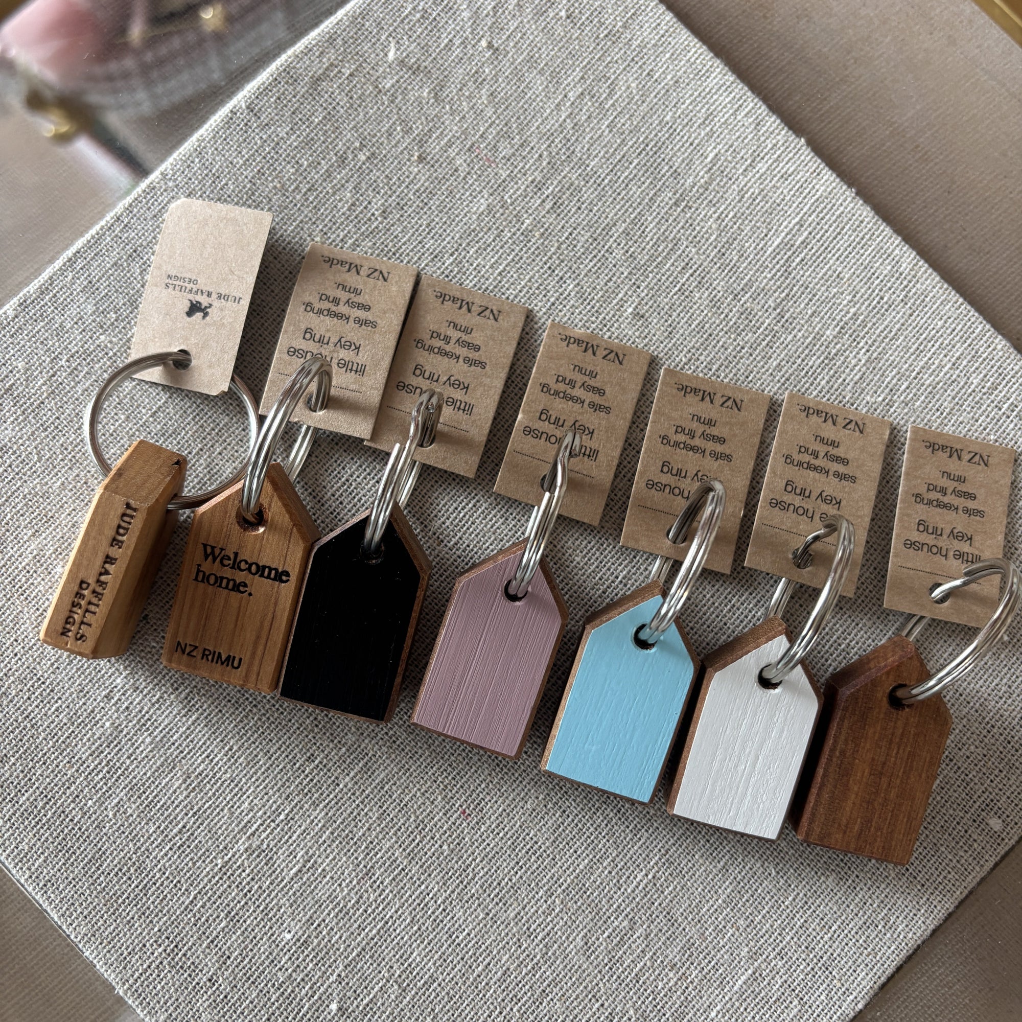 Set of wooden keychains with engraved text on a textured surface