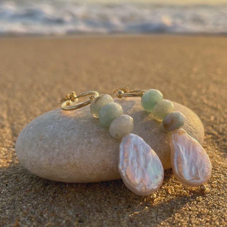 Jewelry set with pearls and beads on a stone by the beach