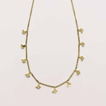 Gold necklace with small pendants on a light pink background