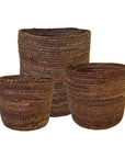 Three woven brown baskets of different sizes on a white background