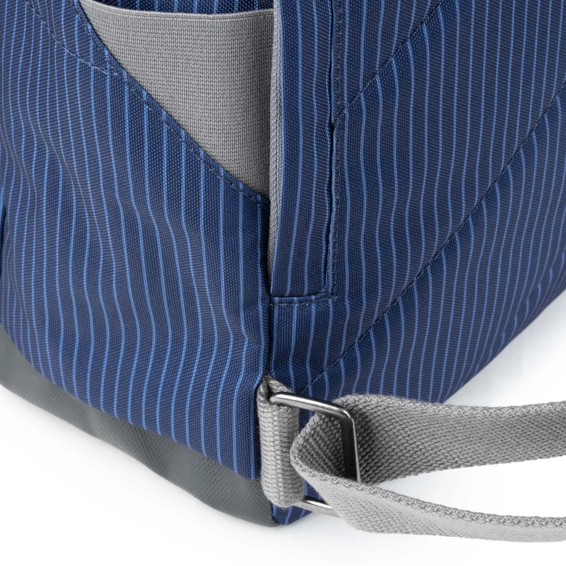 Close-up of a blue pinstripe bag with gray interior and strap on a white background