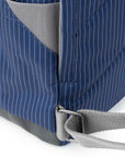 Close-up of a blue pinstripe bag with gray interior and strap on a white background