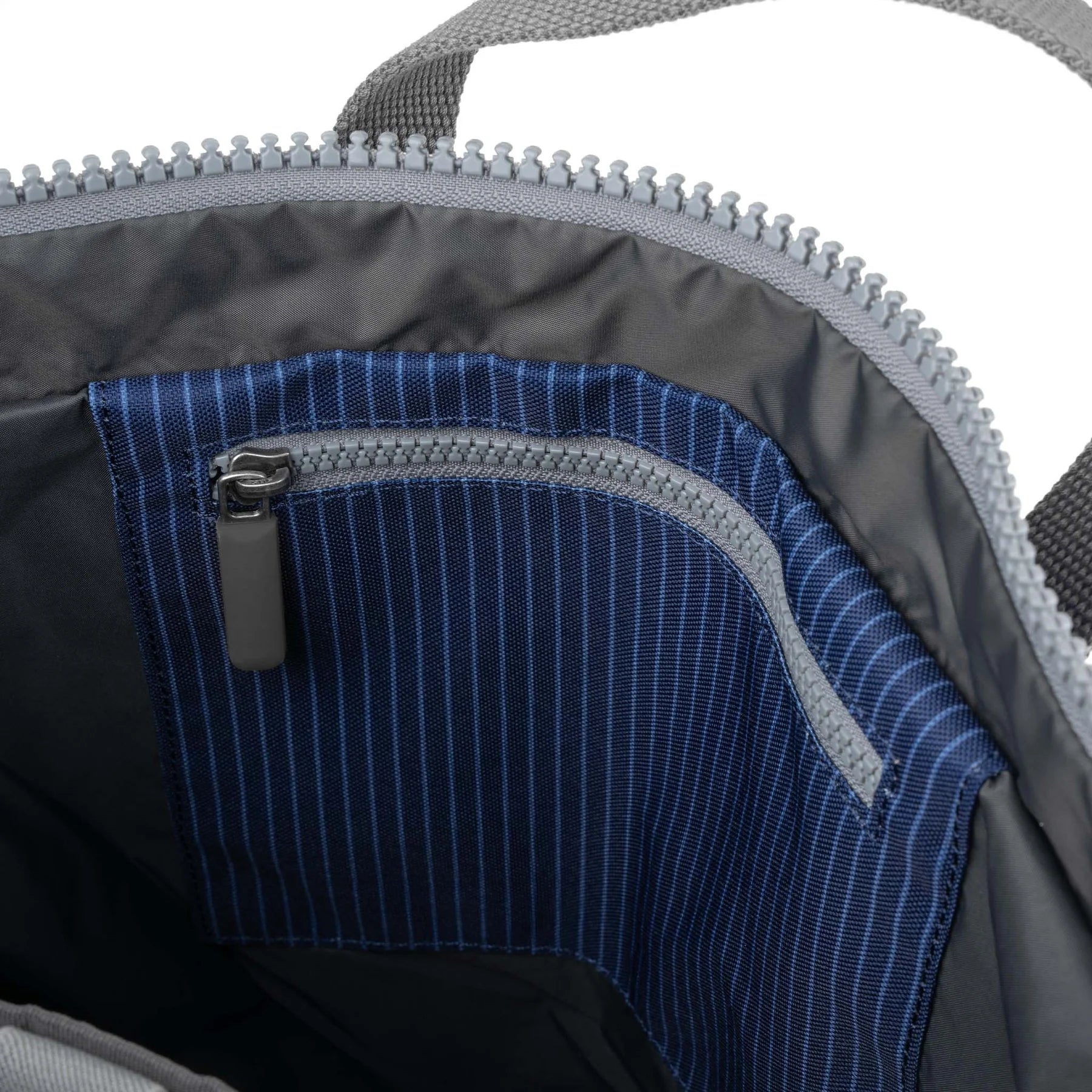 Close-up of a blue zipper pocket on a gray bag