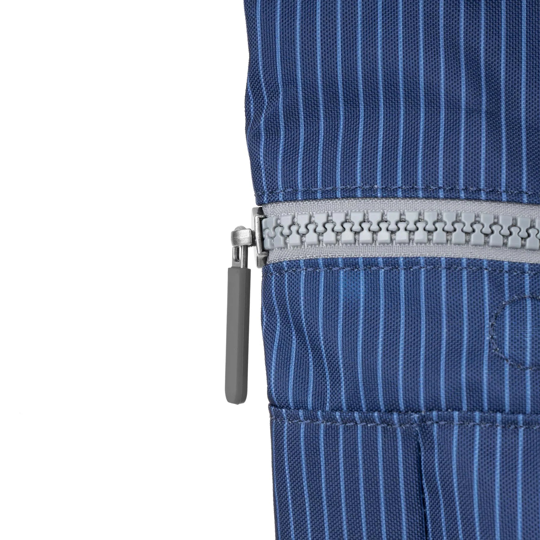 Close-up of a blue pinstripe garment with a zipper on a white background