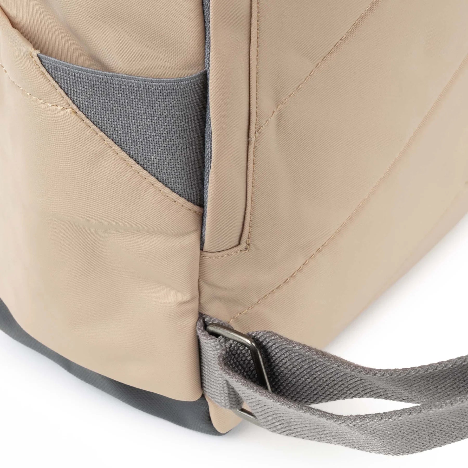 Close-up of a beige backpack with gray straps on a white background