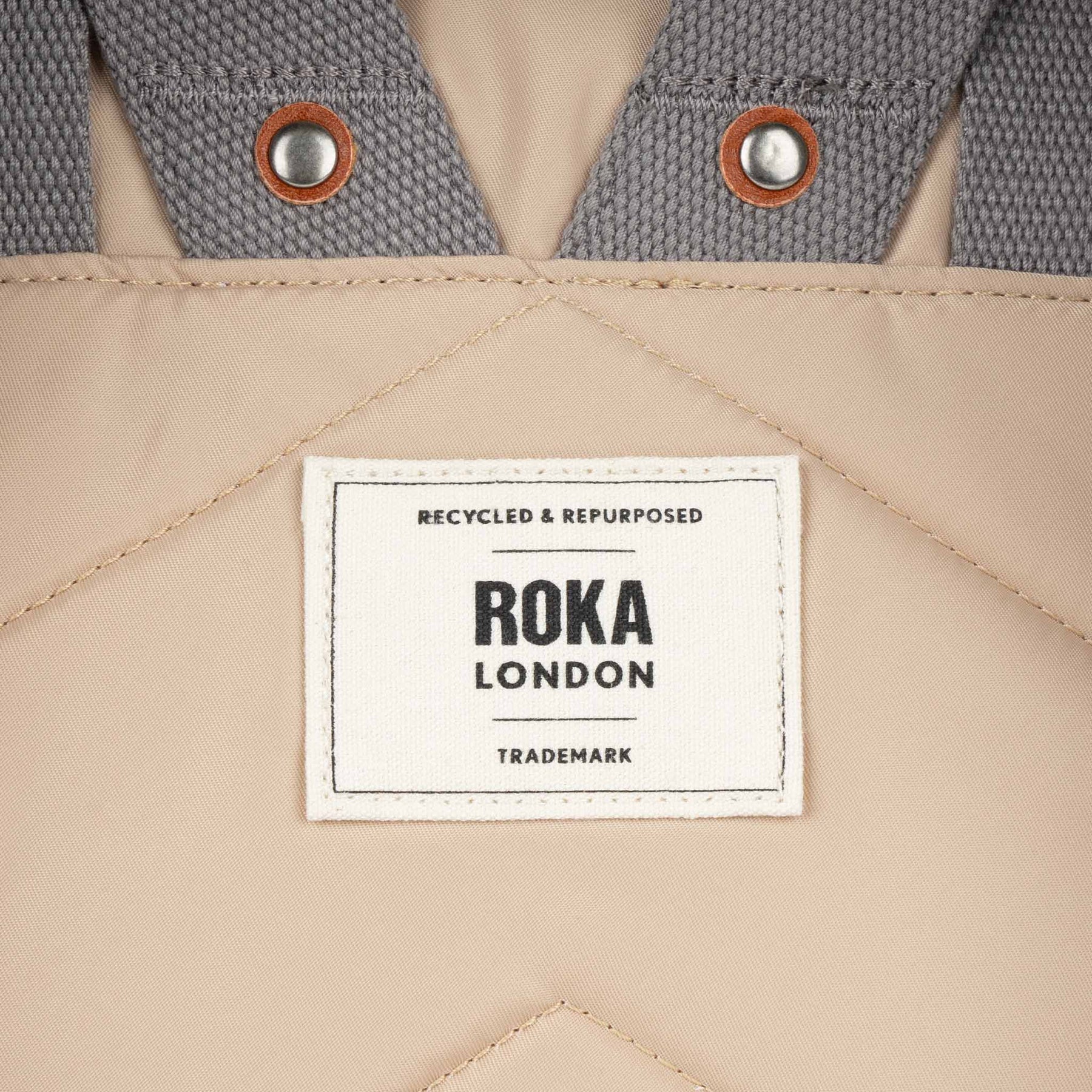 Roka London label on a beige and gray fabric background