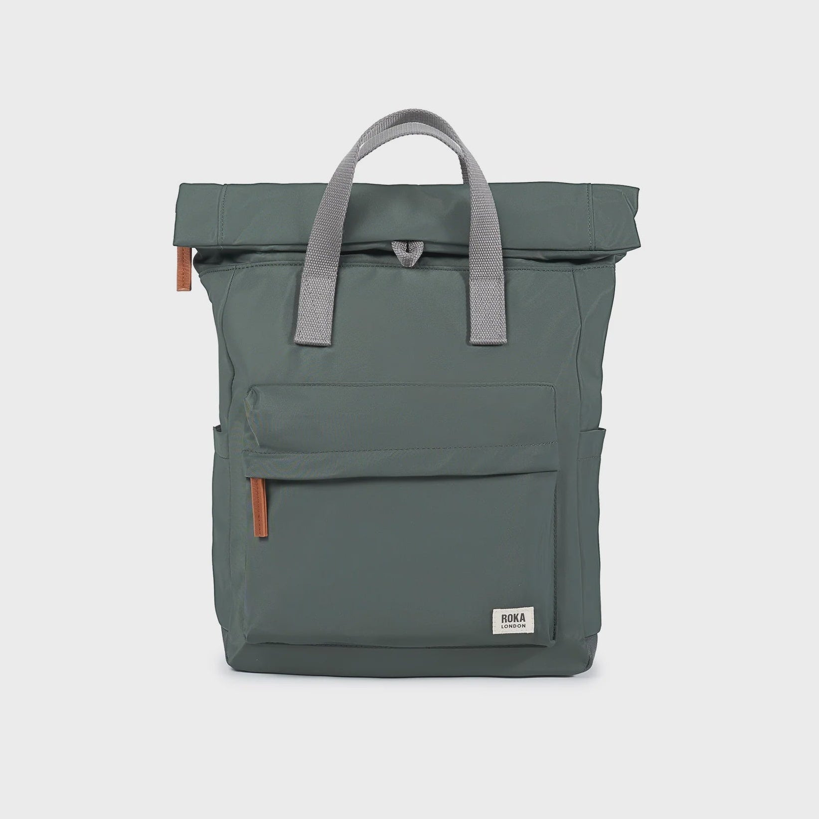 Green backpack with gray handle on a light gray background