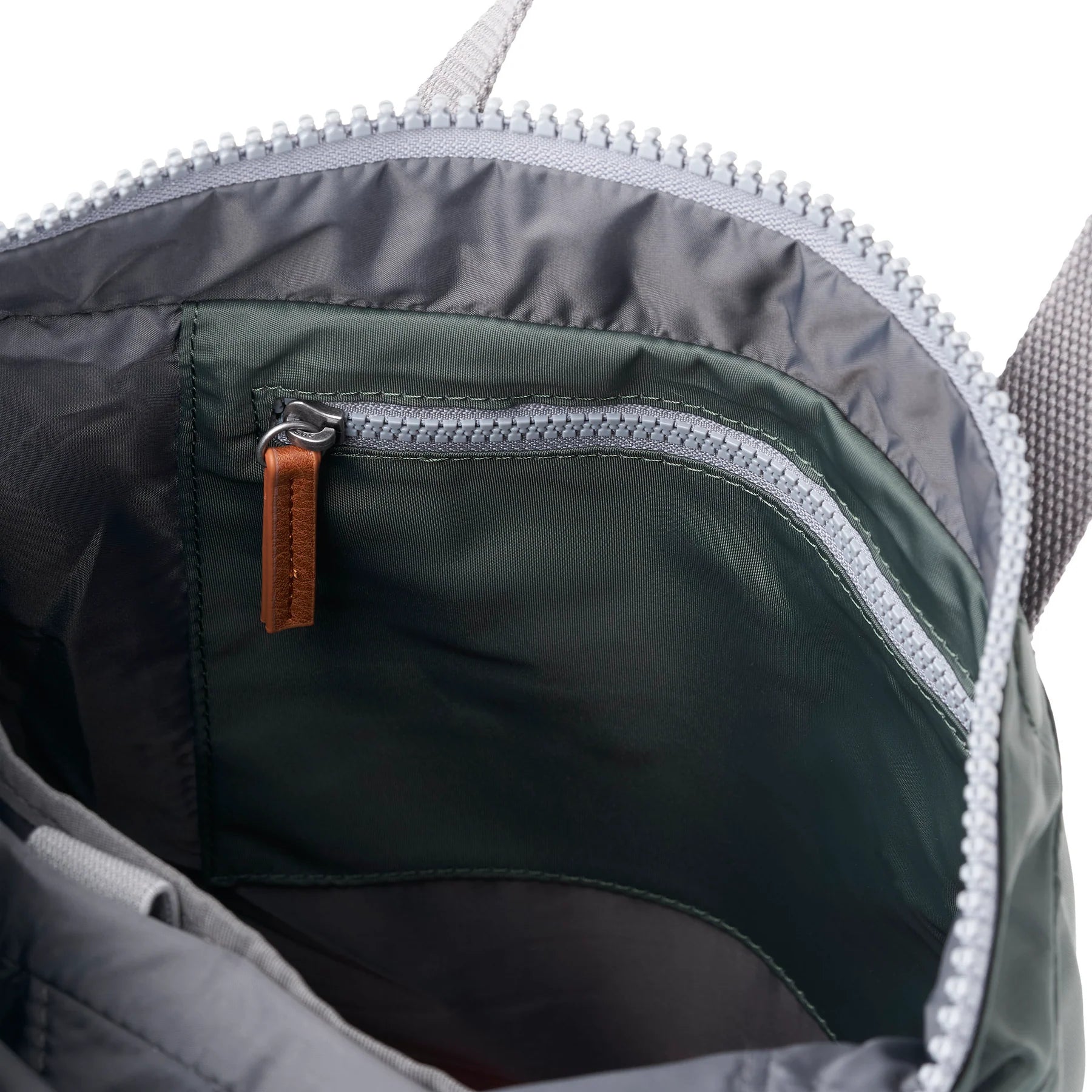 Close-up of a backpack's interior zipper with a brown pull tab.
