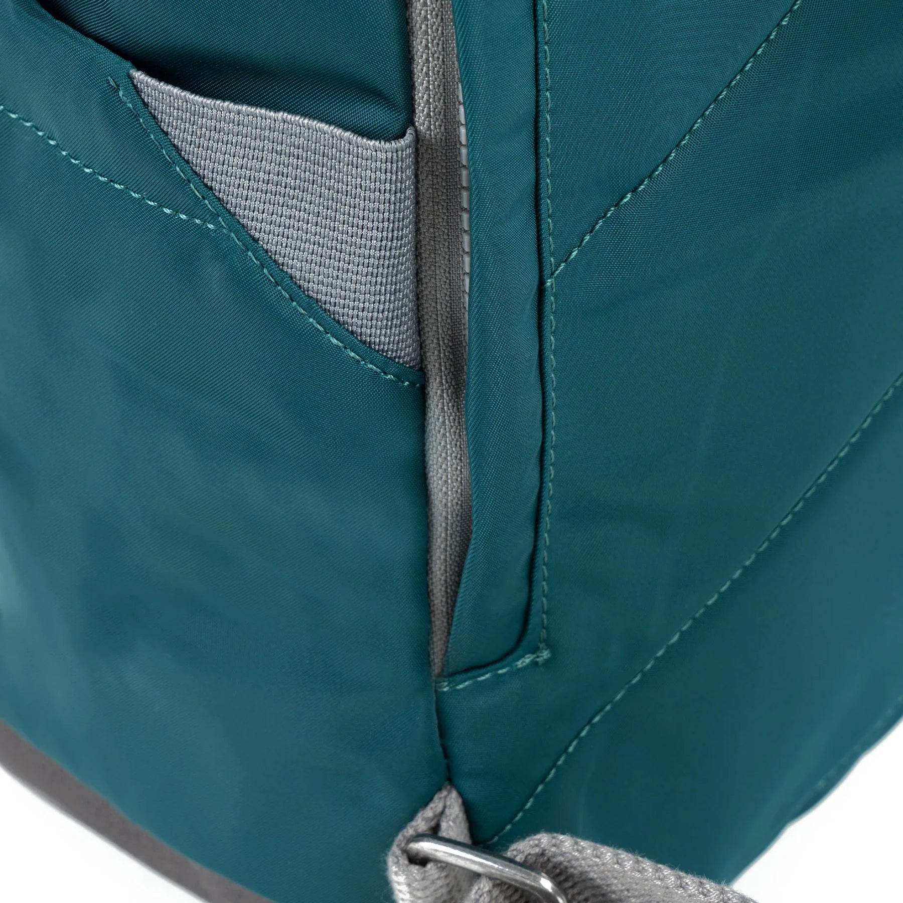 Close-up of a teal bag with gray interior lining on a white background