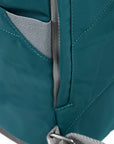 Close-up of a teal bag with gray interior lining on a white background