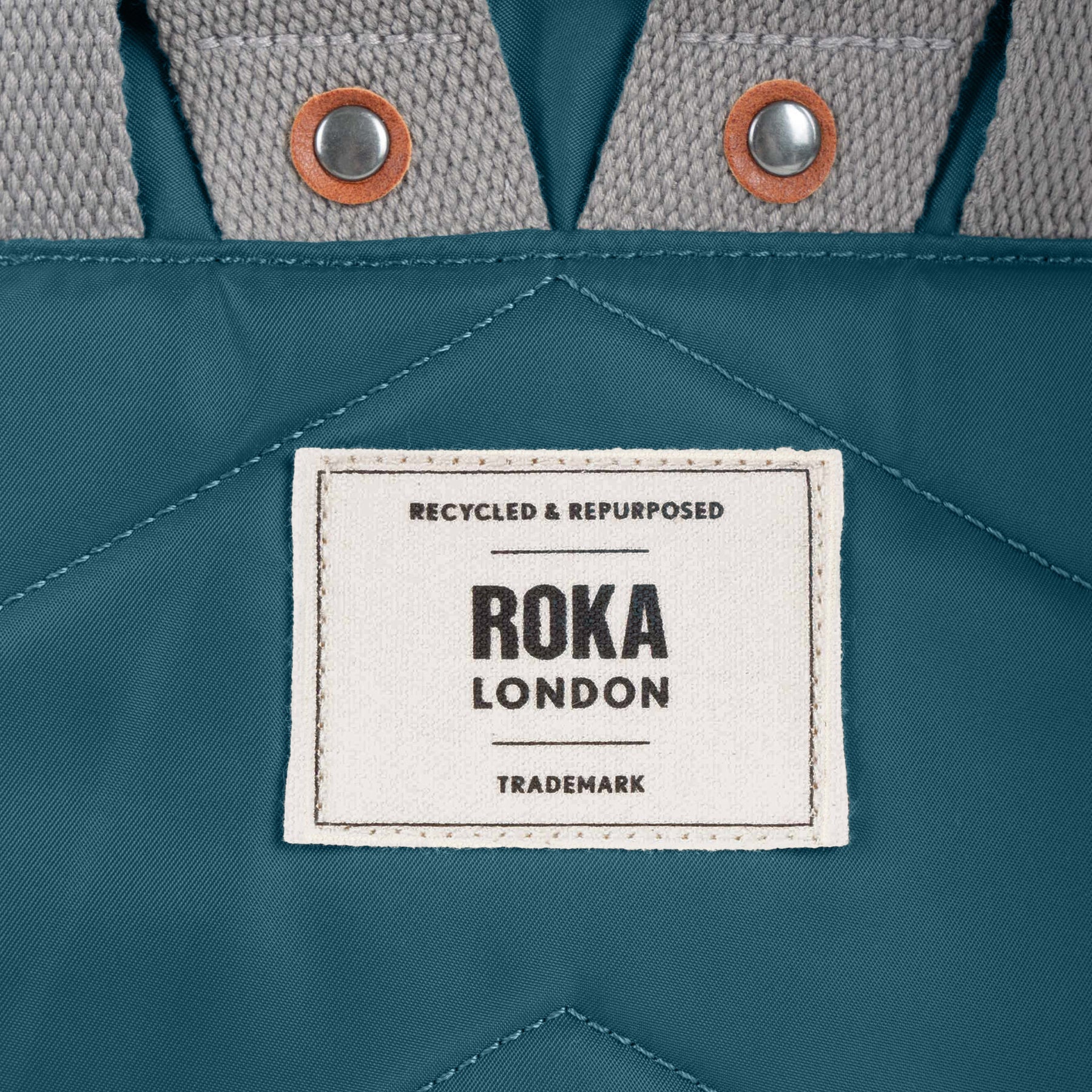 Roka London label on a teal fabric background