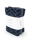 A pack of three Ecovack dish cloths folded and wrapped in a white paper band, featuring a navy blue and gray chevron pattern.