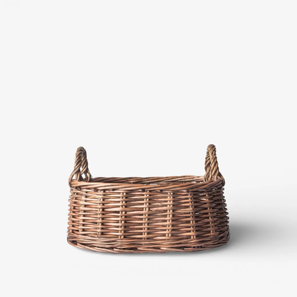 Wicker basket with handles on a white background