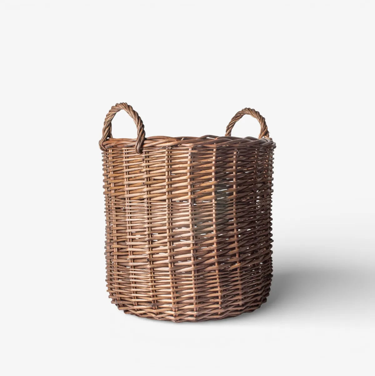 Wicker laundry basket with handles on a white background
