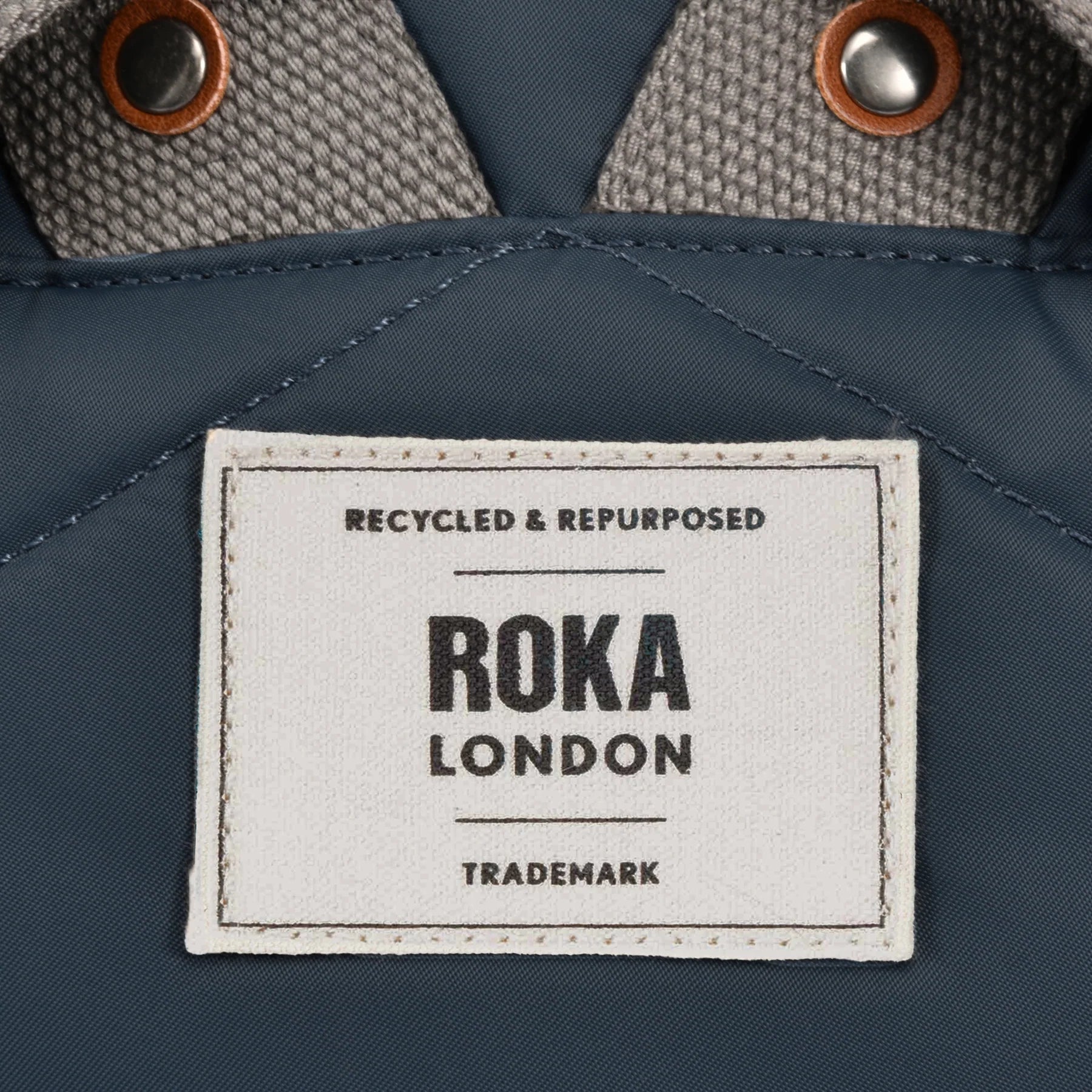 Roka London label on a blue fabric background