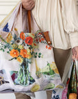 Person holding a colorful floral-patterned bag with a white background