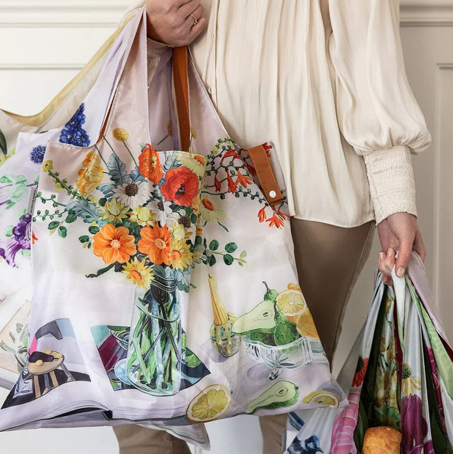 Person holding a colorful floral-patterned bag with a white background