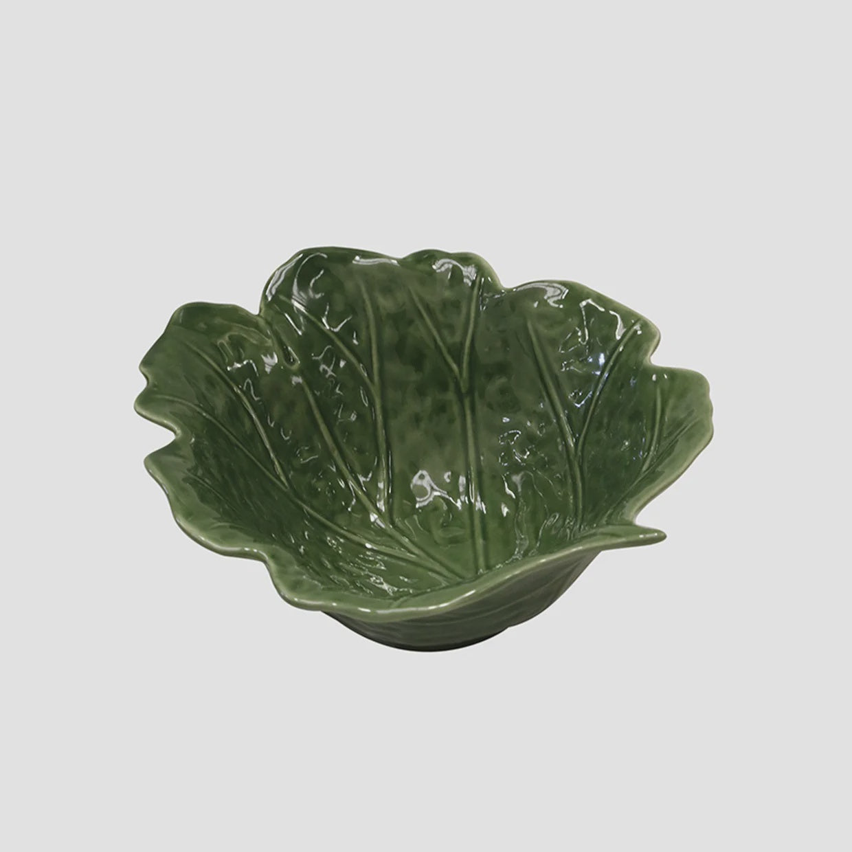 Green leaf-shaped ceramic bowl on a light gray background