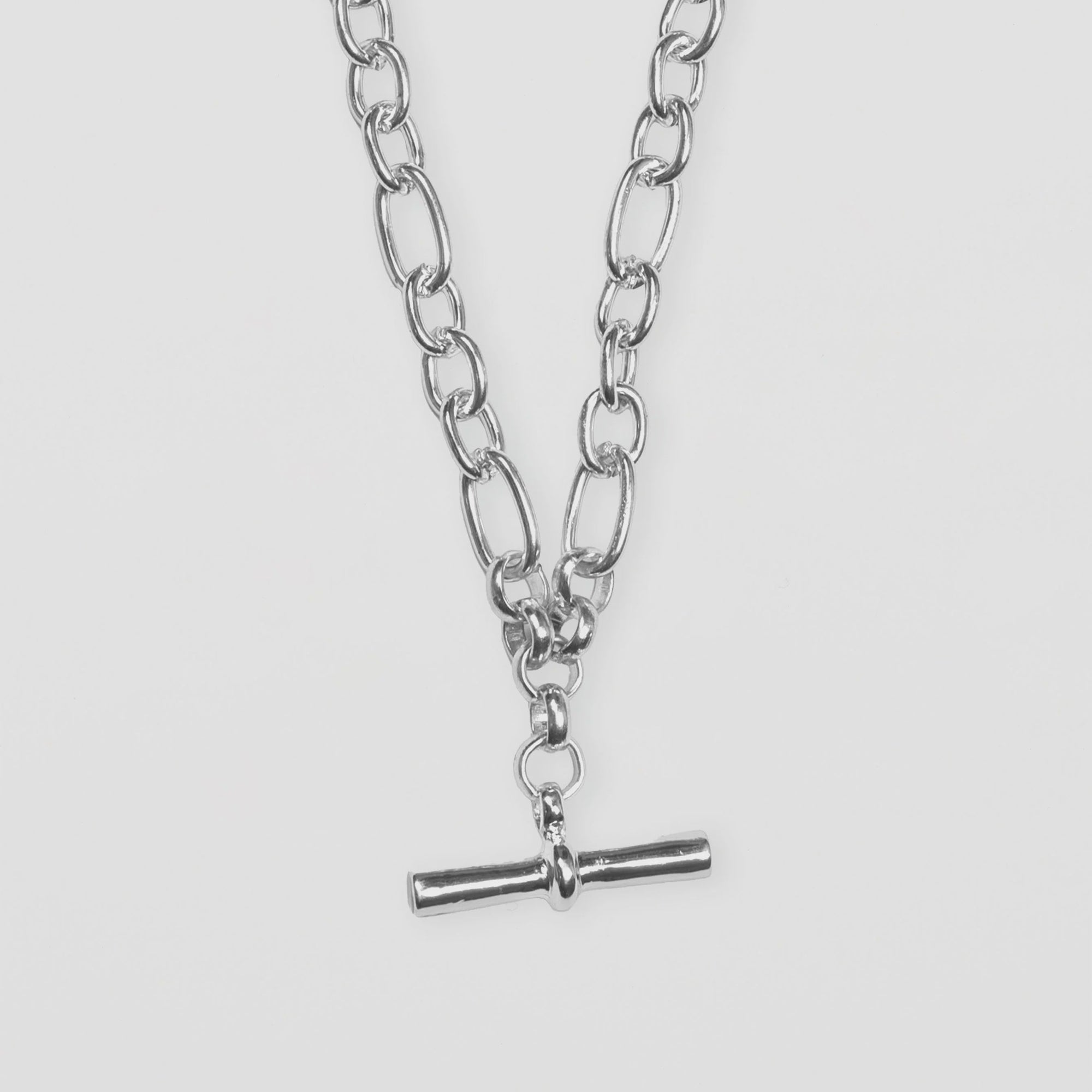 Silver chain necklace with a pendant on a white background