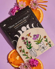 Product packaging with floral design and oranges on a purple background