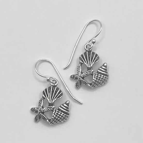 Pair of silver earrings with shell and starfish designs on a light gray background