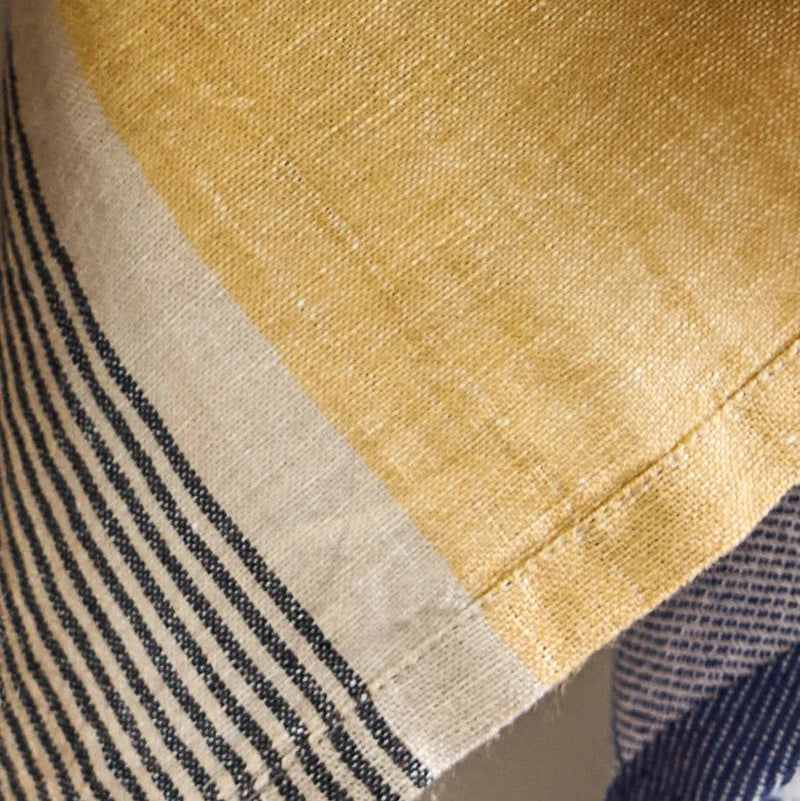Close-up of fabric with yellow, beige, and blue patterns