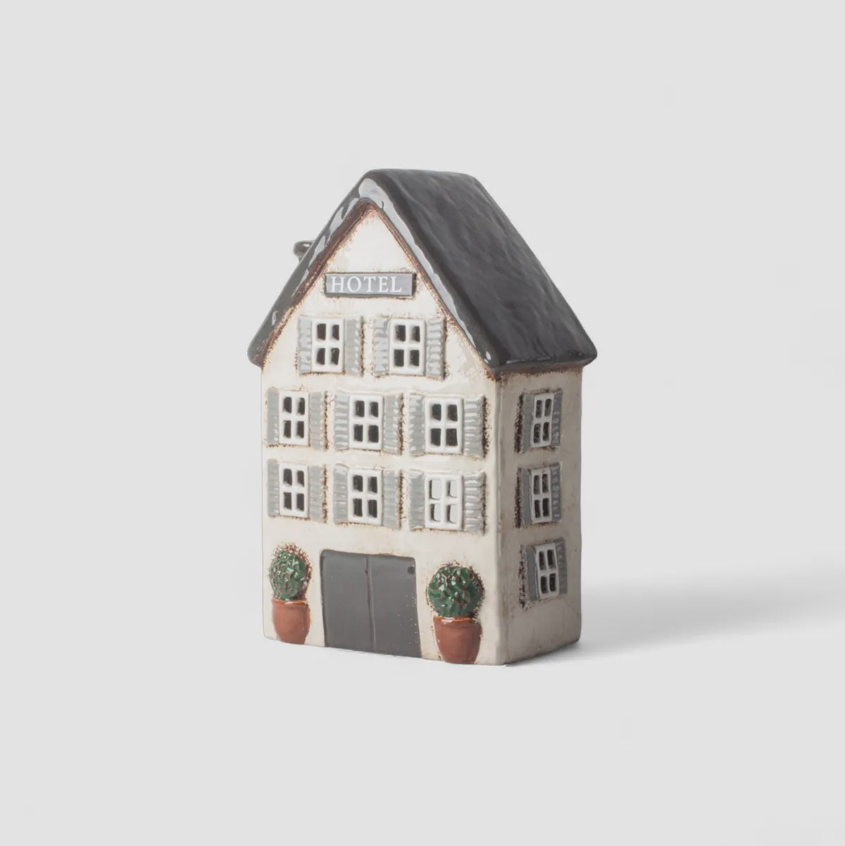 Decorative house-shaped container with a black roof on a white background