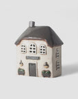 Small ceramic house model with 'Patisserie' sign on a white background