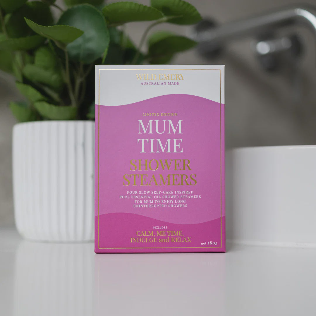 Box of 'Mum Time' shower steamers on a bathroom counter with a plant in the background