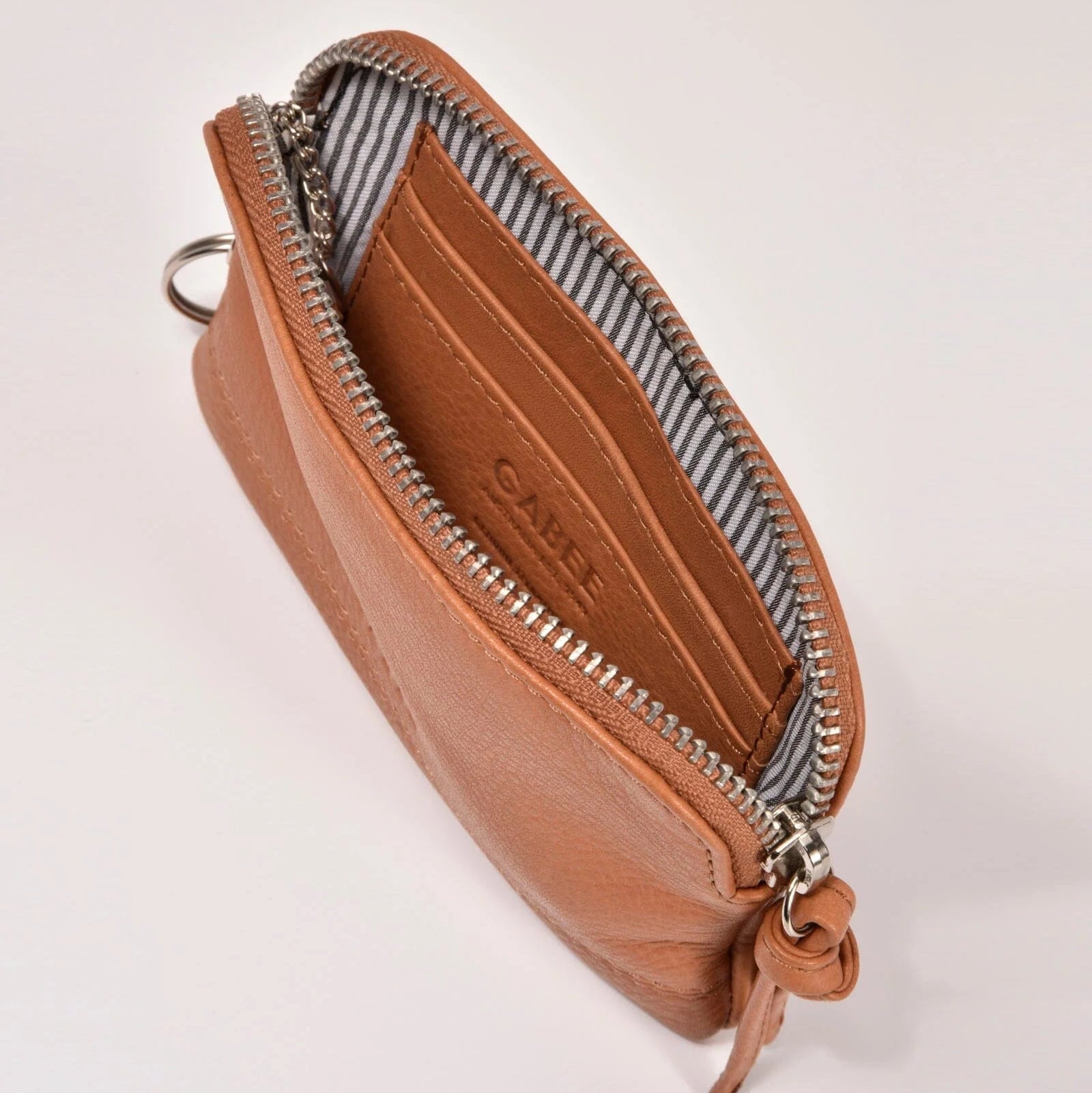 Brown leather pouch with zipper on a light gray background