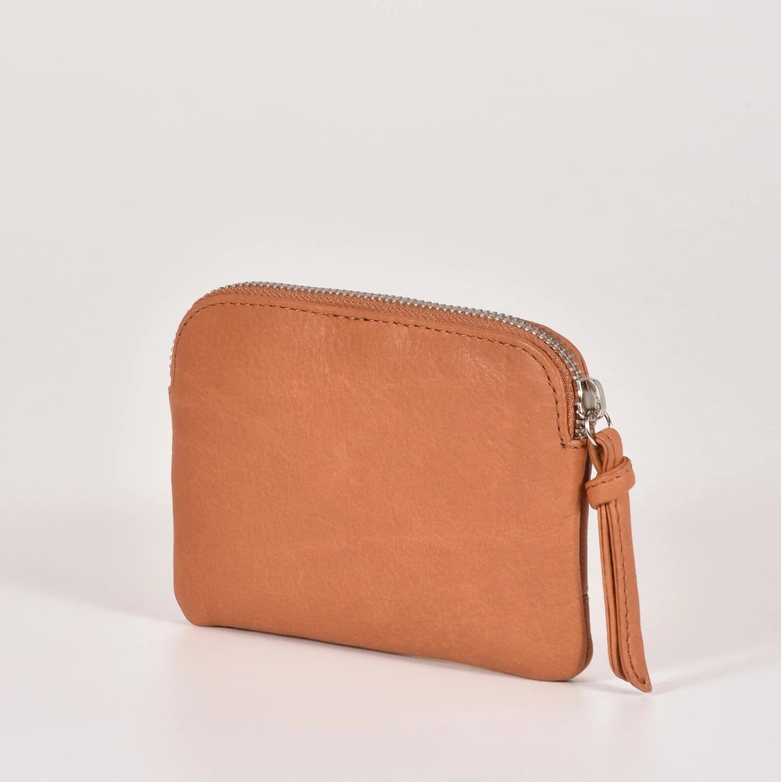 Brown leather wallet with a zipper on a light beige background