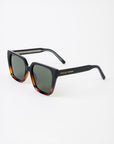 Sunglasses with tortoiseshell frame and dark lenses on a white background