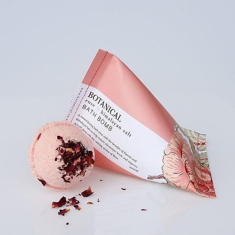 Botanical bath bomb with packaging on a light gray background