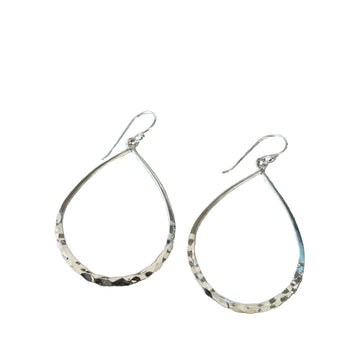 Teardrop-shaped silver earrings on a textured surface