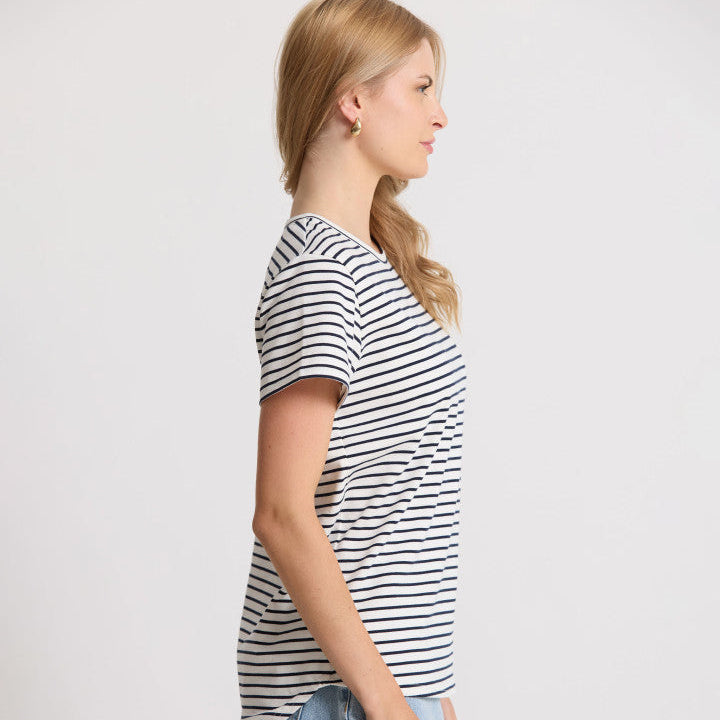 Woman wearing a striped t-shirt and jeans against a plain background