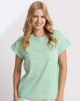 Woman wearing a light green t-shirt on a white background