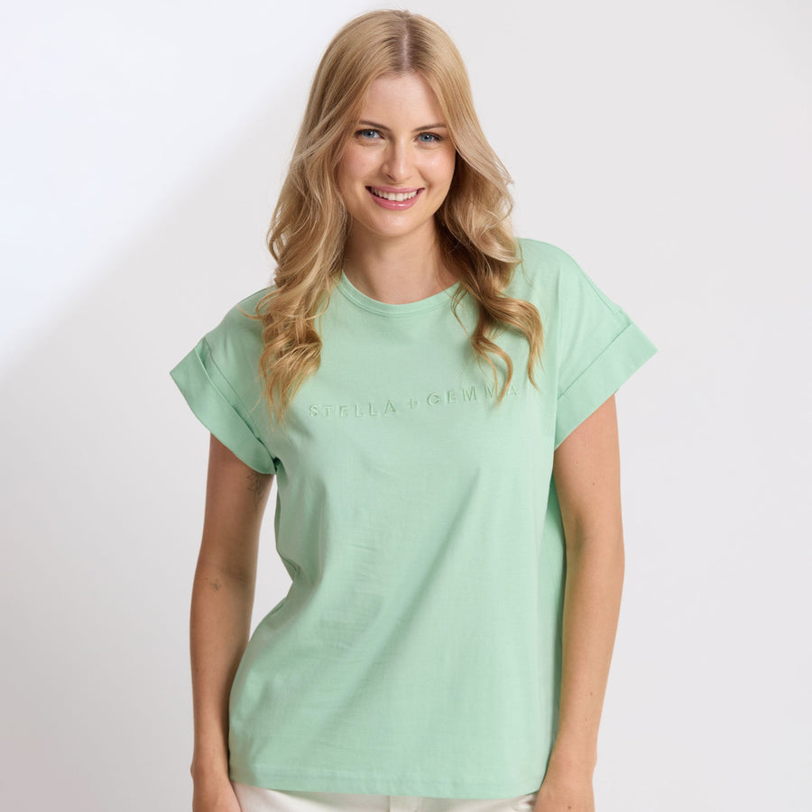Woman wearing a light green t-shirt on a white background